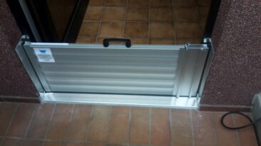 Aluminium-Wasserschott mit Griff, das an einer Tür montiert ist.