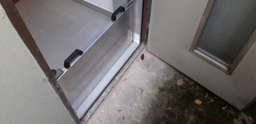 Ein Wasserschott aus Aluminium an einer Tür, das den Bodenbereich abdeckt.
