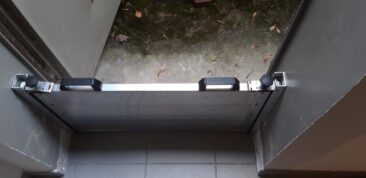 Aluminium-Wasserschott, das an einer Tür montiert ist, mit zwei Griffen und Rollen.
