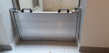 Aluminium-Wasserschott mit zwei Griffen, montiert in einem Innenbereich.