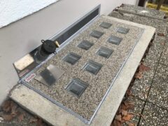 Lichtschachtabdeckung mit mehreren Glas-Elementen und einem Entlüftungsrohr an der Seite.