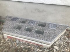 Lichtschachtabdeckung mit mehreren Glas-Elementen und grauer Steinoberfläche.