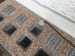 Lichtschachtabdeckung mit mehreren transparenten Elementen und einem Kabelanschluss.